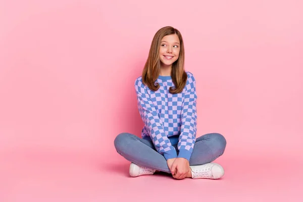 Полноразмерная фотография девочки-подростка, сидящей на промо-носке джинсов с пуловером на розовом фоне — стоковое фото