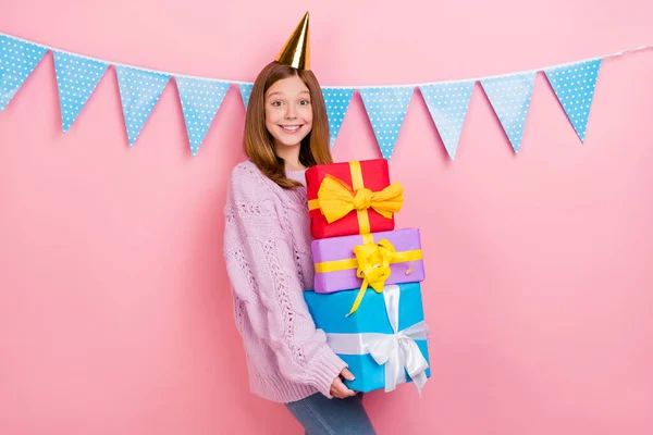 Fotografie krásné sladké dívky pletené svetr headwear držení představuje hromadu izolované růžové barvy pozadí — Stock fotografie