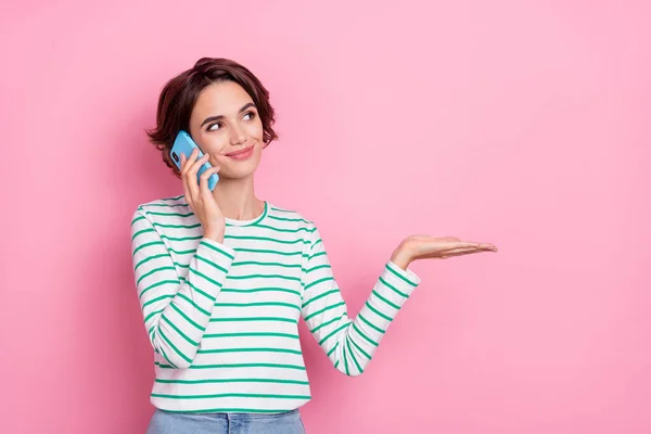 Portré vonzó vidám lány gazdaság tenyér másol üres hely ajánlat beszél telefonon elszigetelt rózsaszín pasztell szín háttér — Stock Fotó