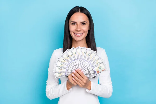 Genç ve güzel bir kadının fotoğrafı nakit para tutuyor. Zengin kazançları mavi arka planda izole edilmiş. — Stok fotoğraf
