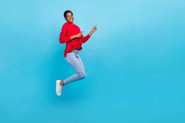 Foto em tamanho completo de pular menina aparência bonita em roupas casuais elegantes promover desconto venda isolado no fundo de cor azul — Fotografia de Stock