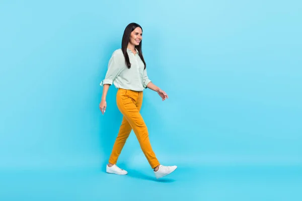 Full body profile side photo of young woman go look empty space wear casual clothes isolated over blue color background — Stock Photo, Image