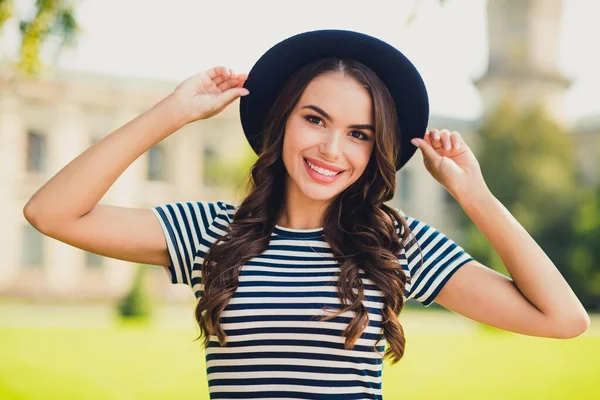 Foto de bonita jovem mulher vestida vestido listrado tampão braços andando sorrindo fora bela paisagem — Fotografia de Stock