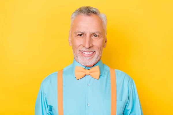 Photo of old grey hairdo man wear teal shirt suspenders bow tie isolated on yellow color background — Stock Photo, Image