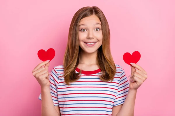 Foto de doce adolescente marrom penteado menina segurar coração desgaste vermelho t-shirt isolado no fundo cor-de-rosa — Fotografia de Stock