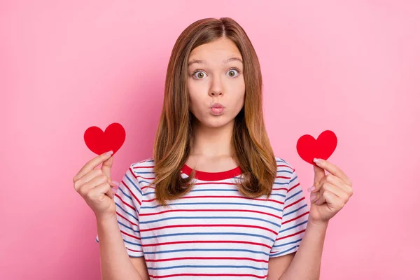 Foto de impressionado adolescente marrom penteado menina segurar coração golpe beijo desgaste vermelho t-shirt isolado no fundo cor-de-rosa — Fotografia de Stock