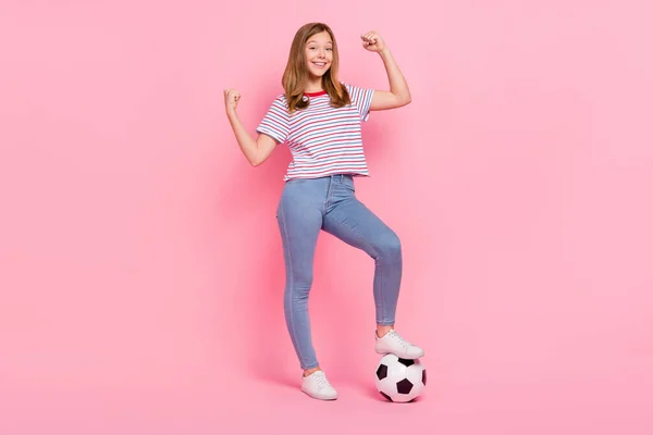 Full size foto di carino bambina bionda giocare a calcio usura t-shirt jeans scarpe isolate su sfondo rosa — Foto Stock