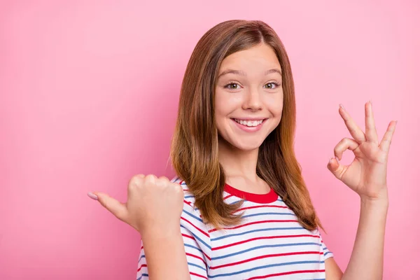 清凉的金发小女孩索引空格的照片显示，欧奇身穿红色T恤，与粉色背景隔离 — 图库照片