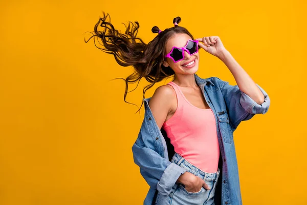 Фотографія профілю молодої веселої дівчини рука торкається вечірки окулярів ізольовано на жовтому кольоровому фоні — стокове фото