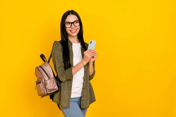 Bild av fin tusenårig dam hålla telefon look promo bära väska glasögon skjorta isolerad på gul bakgrund — Stockfoto