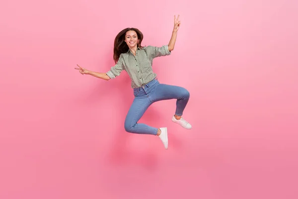 Photo of charming funny woman wear striped shirt showing v-sign jumping high isolated pink color background — Stock Photo, Image