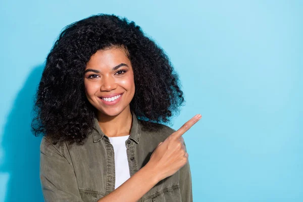 Foto de jovem senhora africana alegre indicar dedo espaço vazio anunciar promoção escolha isolada sobre fundo de cor azul — Fotografia de Stock