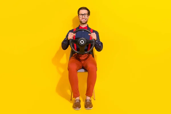 Full body photo of young anxious man ride auto bite lips scared fast sit stool isolated over yellow color background — Stock Photo, Image