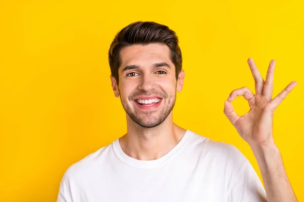 Foto do promotor alegre homem mostrar okey símbolo dedos desgaste branco t-shirt isolado cor amarela fundo — Fotografia de Stock
