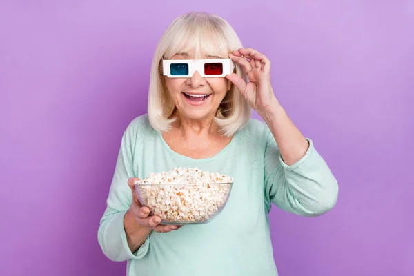 Photo of surprised cheerful glad lady hold pop corn bowl wear 3d glasses teal shirt isolated violet color background — Stock Photo, Image