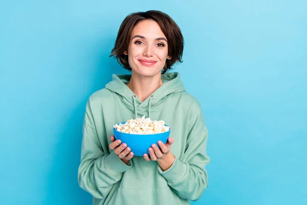 Photo de douce jeune femme coiffure bob tenir nourriture porter sweat à capuche isolé sur fond bleu — Photo