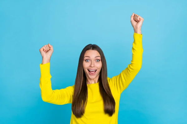 Foto de hooray joven morena manos puños gritan usar camisa amarilla aislada sobre fondo de color azul —  Fotos de Stock