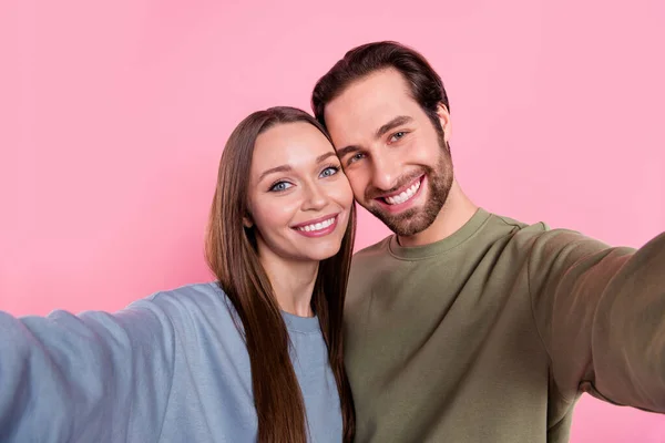 Портрет двох веселих привабливих людей робить селфі запис відео ізольованим на рожевому кольоровому фоні — стокове фото