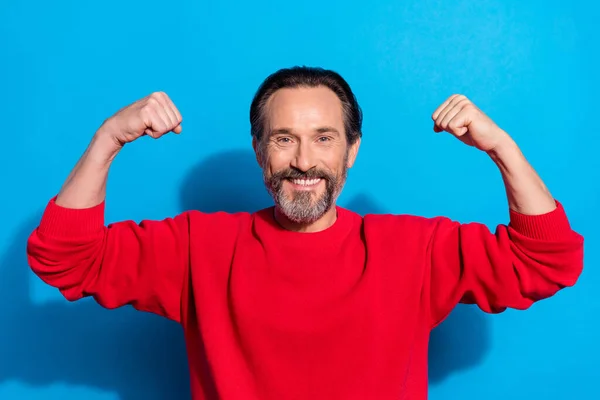 Portrait de l'homme fort joyeux attrayant démontrant les muscles isolés sur fond bleu vif — Photo