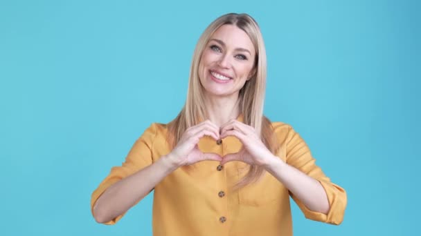 Pozitív hölgy ügynök, hogy szerelem jel elszigetelt kék szín háttér — Stock videók