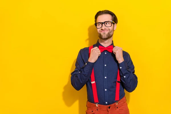 Foto van de jongeman voor te bereiden partij juiste bowtie blik lege ruimte geïsoleerd over gele kleur achtergrond — Stockfoto