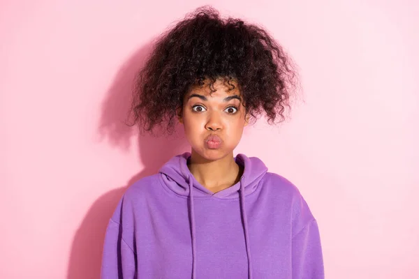 Photo of carefree excited person holding breath pouted cheeks look camera isolated on pink color background