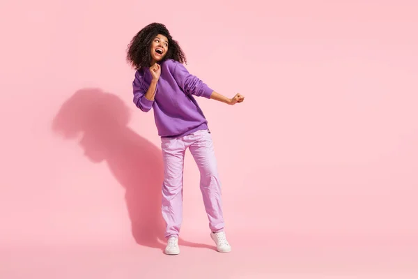 Foto de linda chica afro encantadora usar sudadera violeta bailando cantando espacio vacío sonriendo aislado color rosa fondo —  Fotos de Stock