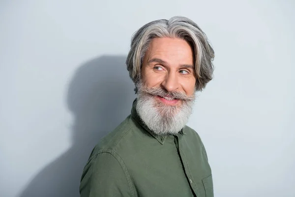 Portrait of attractive cheerful curious grey-haired man copy empty space looking aside isolated over gray pastel color background — Stock Photo, Image