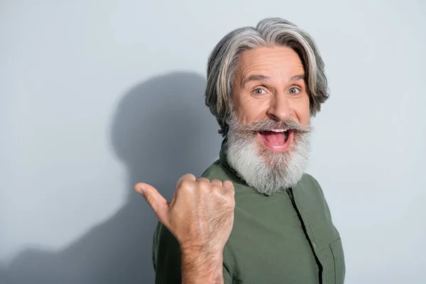 Portrait of attractive cheerful lucky grey-haired man demonstrating copy empty space solution isolated over gray pastel color background — Stock Photo, Image