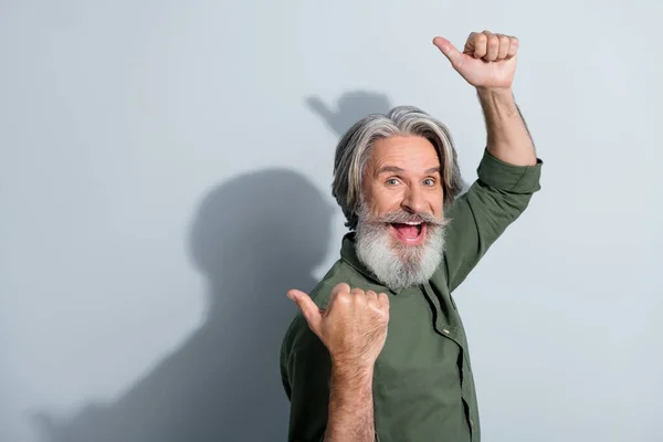 Retrato de atractivo hombre de pelo gris alegre demostrando copia espacio vacío lugar anuncio aislado sobre fondo de color pastel gris — Foto de Stock