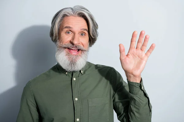Ritratto di bello allegro amichevole uomo dai capelli grigi agitando palma ciao isolato su sfondo grigio pastello colore — Foto Stock