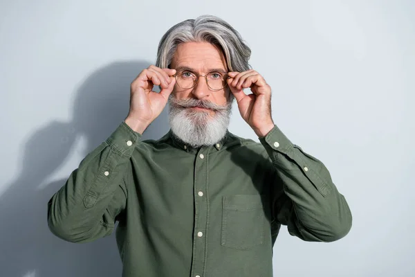 Portrait d'homme aux cheveux gris expérimenté attrayant touchant les spécifications isolées sur fond de couleur pastel gris — Photo