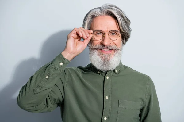 Retrato de atractivo alegre experimentado hombre de pelo gris tocando especificaciones cuidado de la salud aislado sobre fondo de color pastel gris — Foto de Stock
