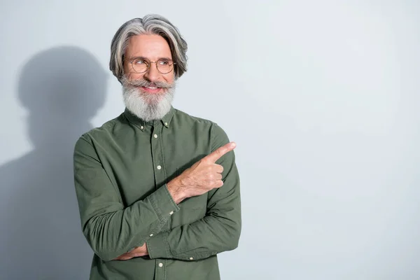Retrato de atractivo hombre de pelo gris alegre mostrando indican índice seleccionar seguir copia espacio aislado sobre gris pastel color fondo — Foto de Stock