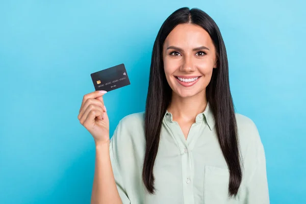 Фото молодої веселої дівчини тримають кредитну картку заробітна плата прибуток ізольовано на синьому кольоровому фоні — стокове фото