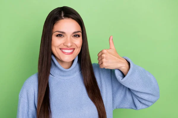 Foto de mulher muito adorável jovem usar camisola azul sorrindo mostrando polegar para cima isolado cor verde fundo — Fotografia de Stock