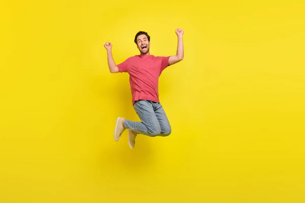 Full body photo of cool brunet millennial guy jump yell wear t-shirt jeans shoes isolated on yellow background — Stock Photo, Image