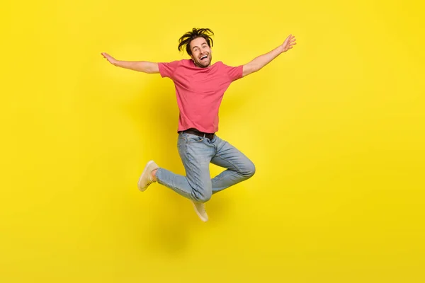 Full size photo of hooray brunet young guy jump wear t-shirt jeans footwear isolated on yellow background — Stock Photo, Image