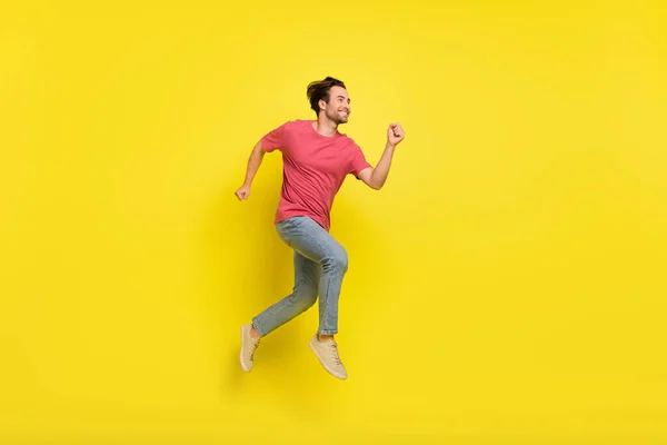 Corpo inteiro foto de barba agradável millennial cara executar desgaste vermelho t-shirt jeans sapatos isolados no fundo amarelo — Fotografia de Stock