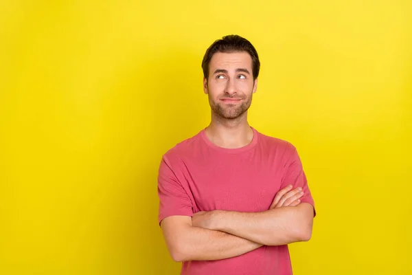 Foto de mentalidad pensativo interesado tipo cruzó brazos mirada espacio vacío desgaste rosa camiseta aislado color amarillo fondo — Foto de Stock