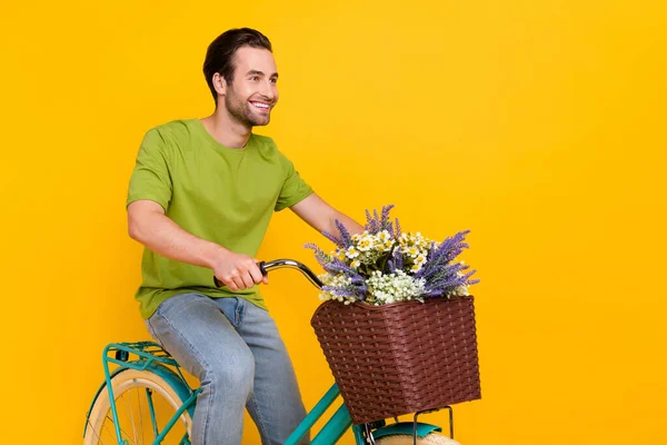 Photo of optimistic brunet hairdo young guy on bicycle wear t-shirt jeans isolated on yellow color background — Stock Photo, Image