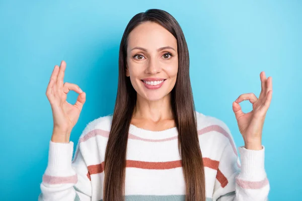 Foto von lustigen selbstbewusste Dame demonstrieren okey Symbole tragen gestreiften Pullover isoliert blaue Farbe Hintergrund — Stockfoto