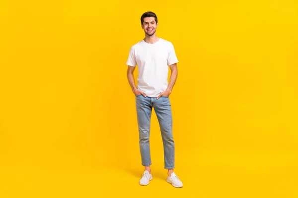 Pełny rozmiar zdjęcie ładne millennial brunet facet stoisko nosić okulary t-shirt dżinsy buty izolowane na żółtym tle — Zdjęcie stockowe