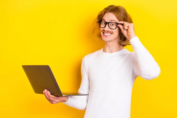 Foto de chico alegre de ensueño usar gafas de brazo camisa blanca trabajando gadget moderno aislado color amarillo fondo —  Fotos de Stock