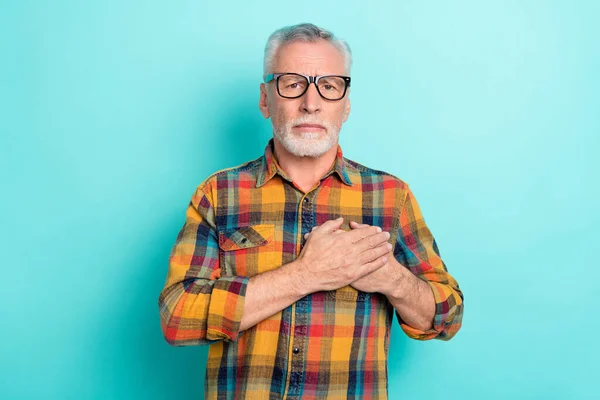 Фото несчастного пенсионера, одетого в клетчатые очки рубашки руки сердце чувствует себя плохо изолированный голубой фон — стоковое фото