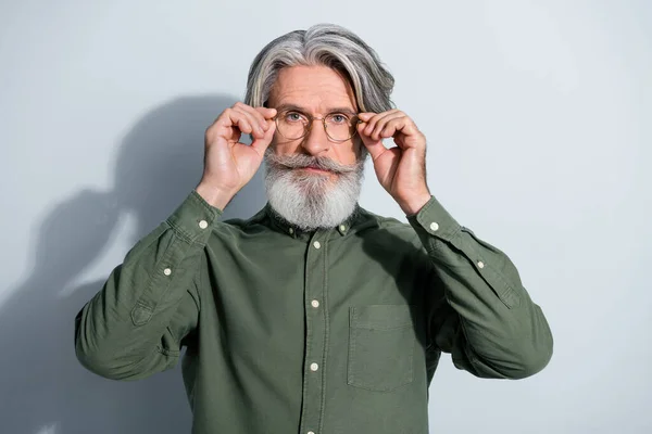 Portrait of attractive skilled experienced grey-haired man touching specs isolated over gray pastel color background — Stock Photo, Image