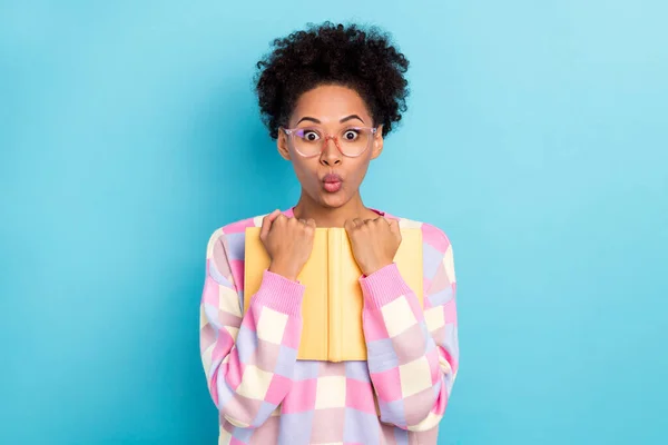 Retrato de atraente na moda surpreendido engraçado menina de cabelos ondulados abraçando lábios de faneca livro isolado sobre fundo de cor azul brilhante — Fotografia de Stock