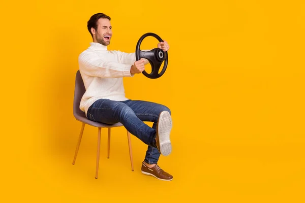 Foto de chocado impressionado cara vestido camisola branca equitação carro perna empurrando pausas isolado cor amarela fundo — Fotografia de Stock