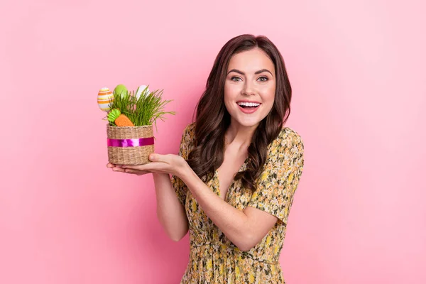 Retrato de chica adorable satisfecha mantenga pequeños huevos cesta mirada cámara aislada sobre fondo de color rosa —  Fotos de Stock