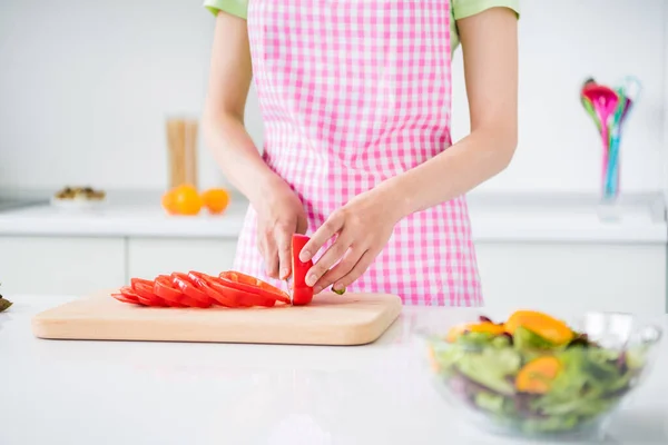 Gesneden foto van jonge dame houden mes snijden verse rode paprika bereiden salade keuken binnen — Stockfoto